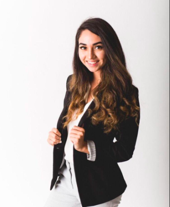 Young woman in a black blazer smiling confidently.