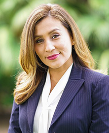 Professional woman in business attire with a confident smile.